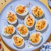 Horizontal overhead image of deviled eggs on a blue tray.
