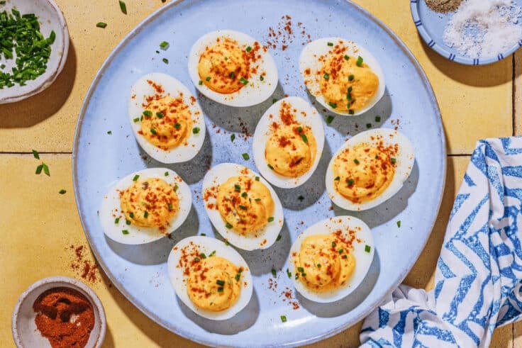 Horizontal overhead image of deviled eggs on a blue tray.