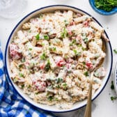 Square overhead shot of a creamy bacon ranch pasta salad recipe in a serving bowl.