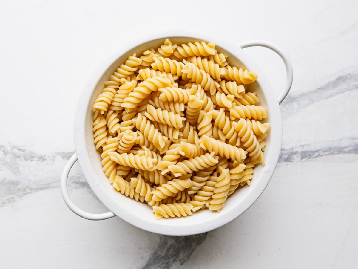 Cooked drained rotini in a colander.