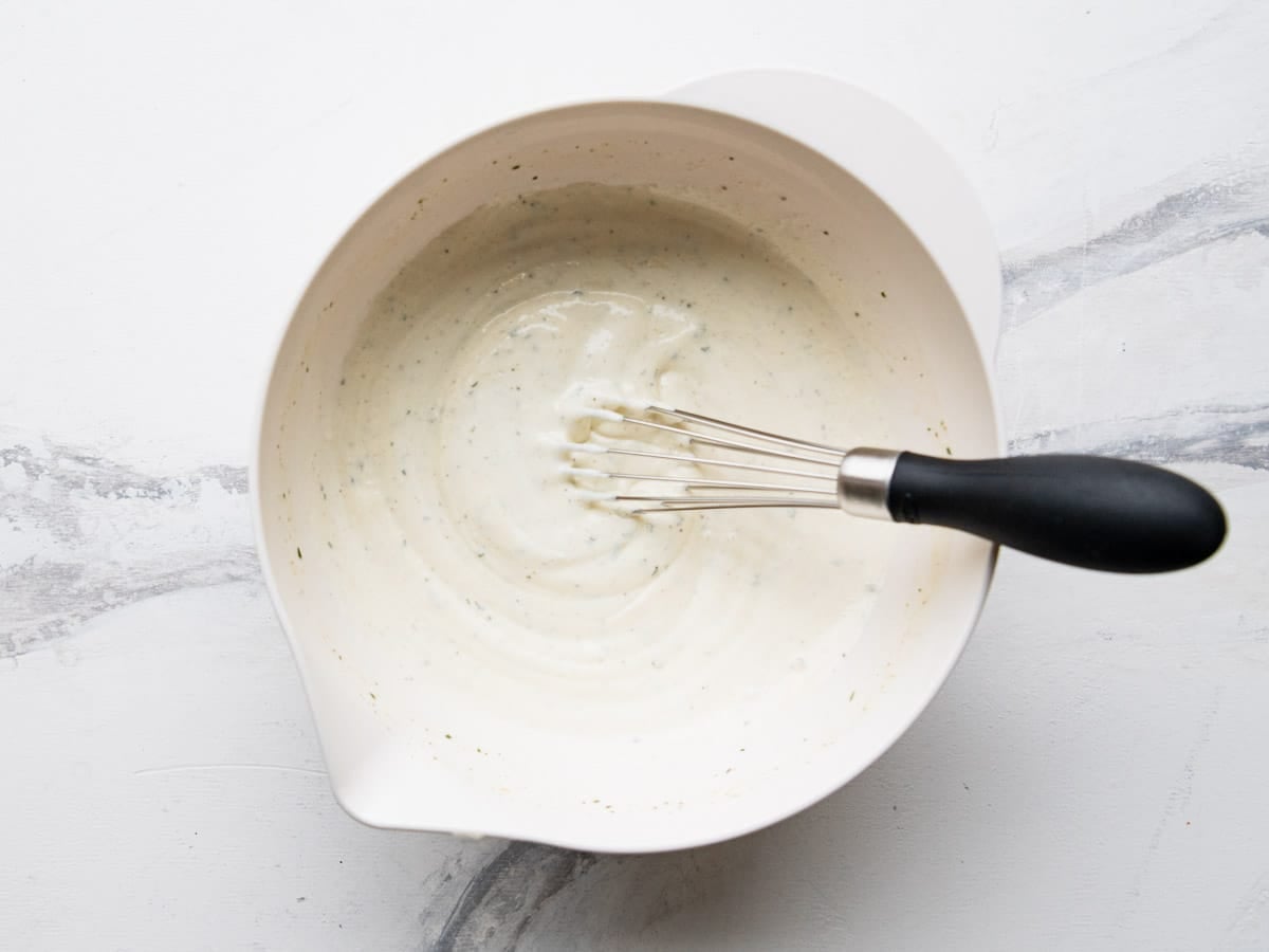 Whisking together the dressing.