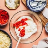 Adding diced pimentos to mayo.