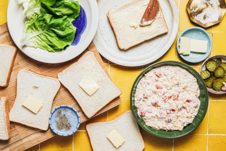 Spreading butter on bread slices.