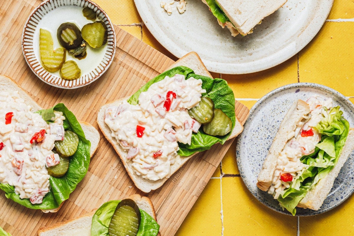 Horizontal overhead shot of pimento cheese spread on bread for sandwiches.