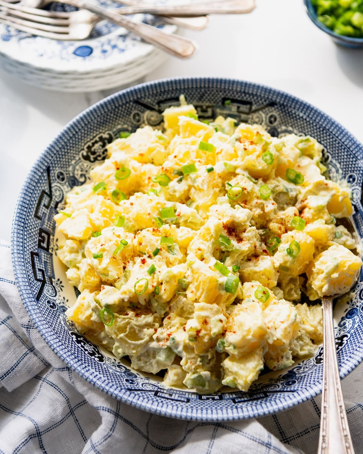 Close up side shot of Southern style potato salad in a blue and white bowl.