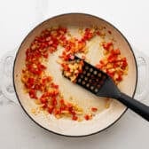 Sauteing bell pepper and onion in a skillet.