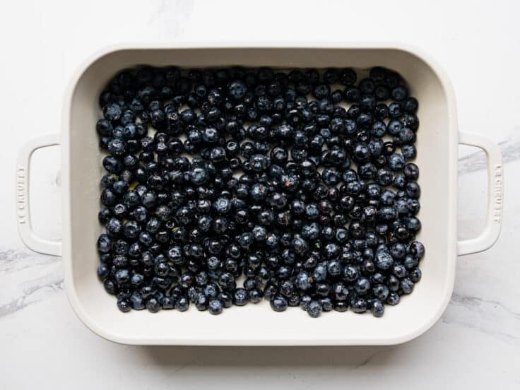 Lemon blueberry filling spread in a baking dish.