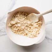 Combining cake mix with melted butter in a bowl.