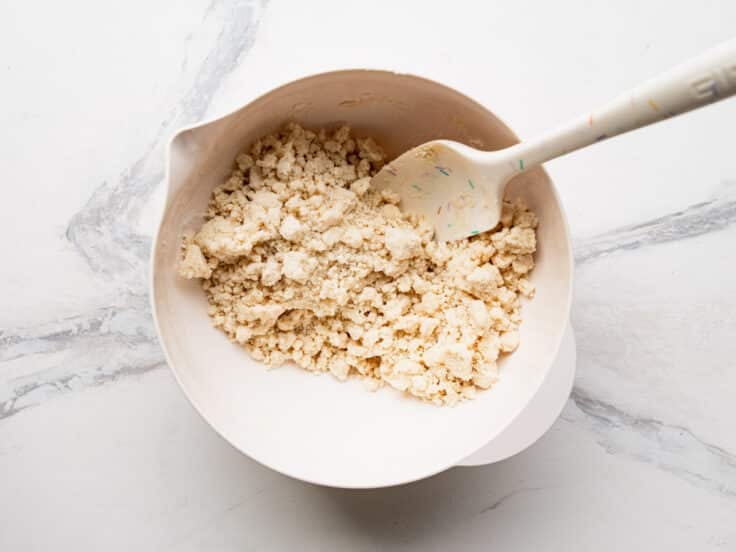 Combining cake mix with melted butter in a bowl.