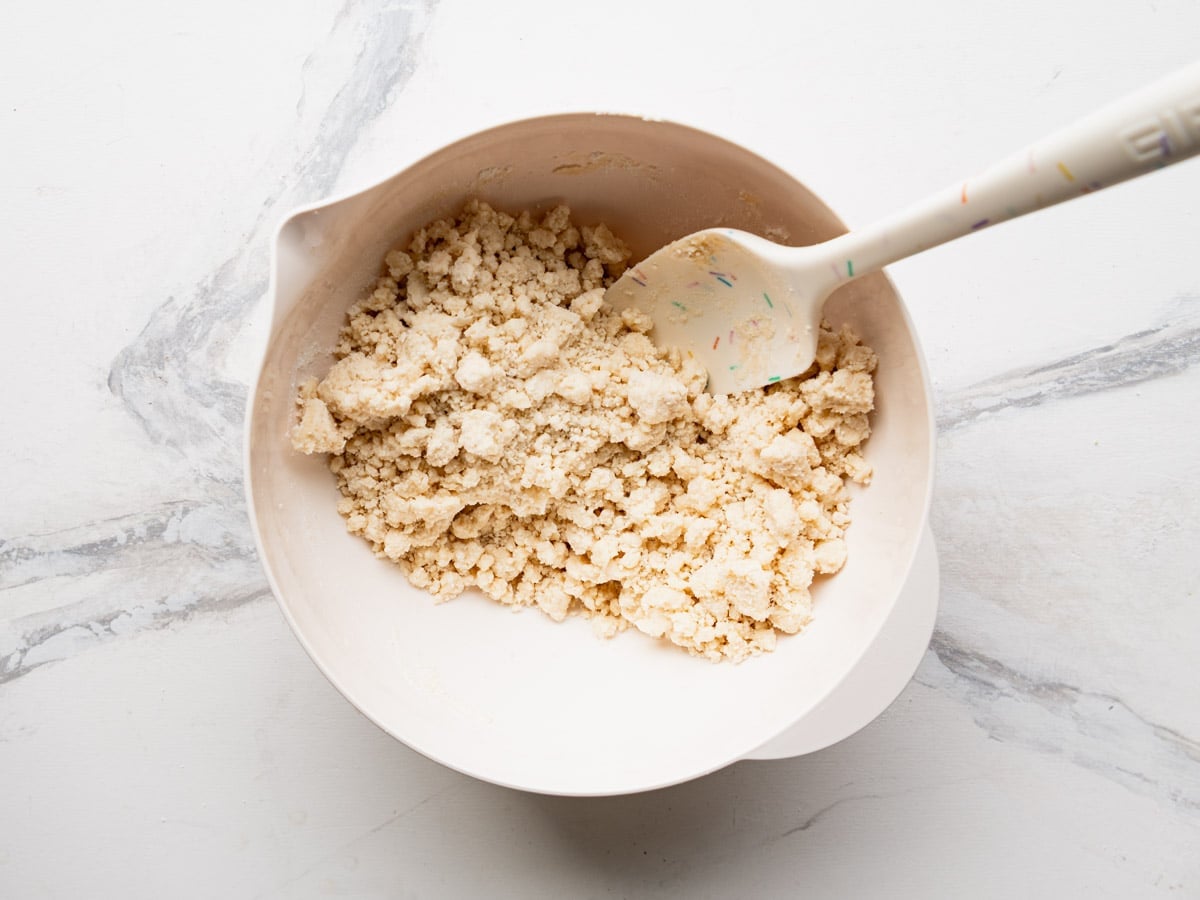 Combining cake mix with melted butter in a bowl.
