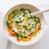 Tossing the dressing with the salad ingredients.
