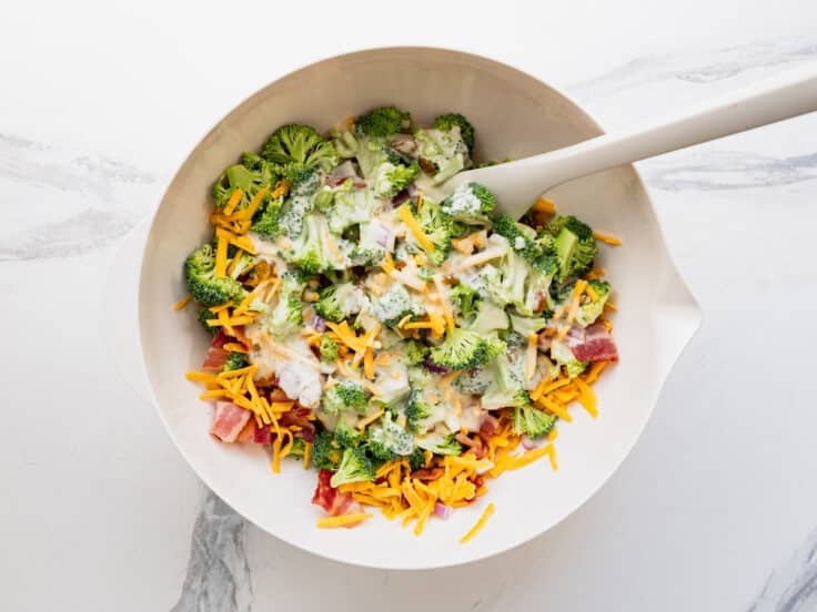 Tossing the dressing with the salad ingredients.