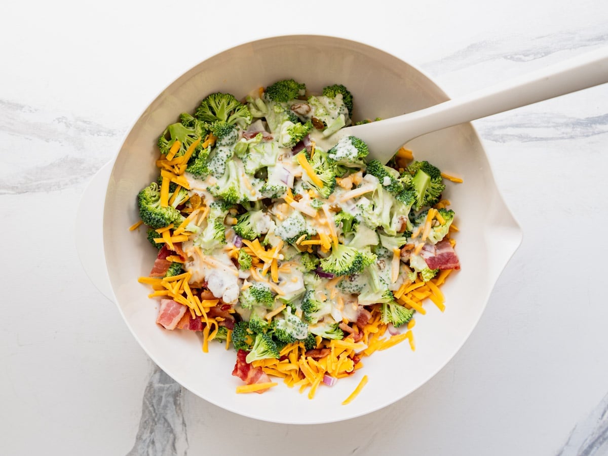 Tossing the dressing with the salad ingredients.
