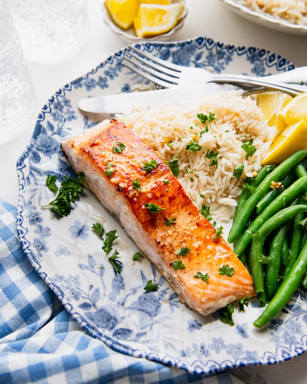 Side shot of garlic butter salmon on a dinner plate.