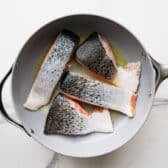 Searing salmon fillets flesh side down.