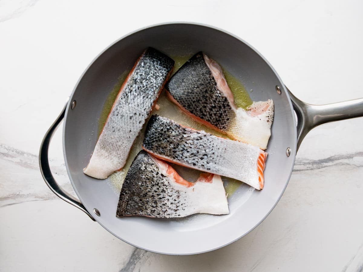 Searing salmon fillets flesh side down.