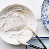 Dredging chicken cutlets in flour.
