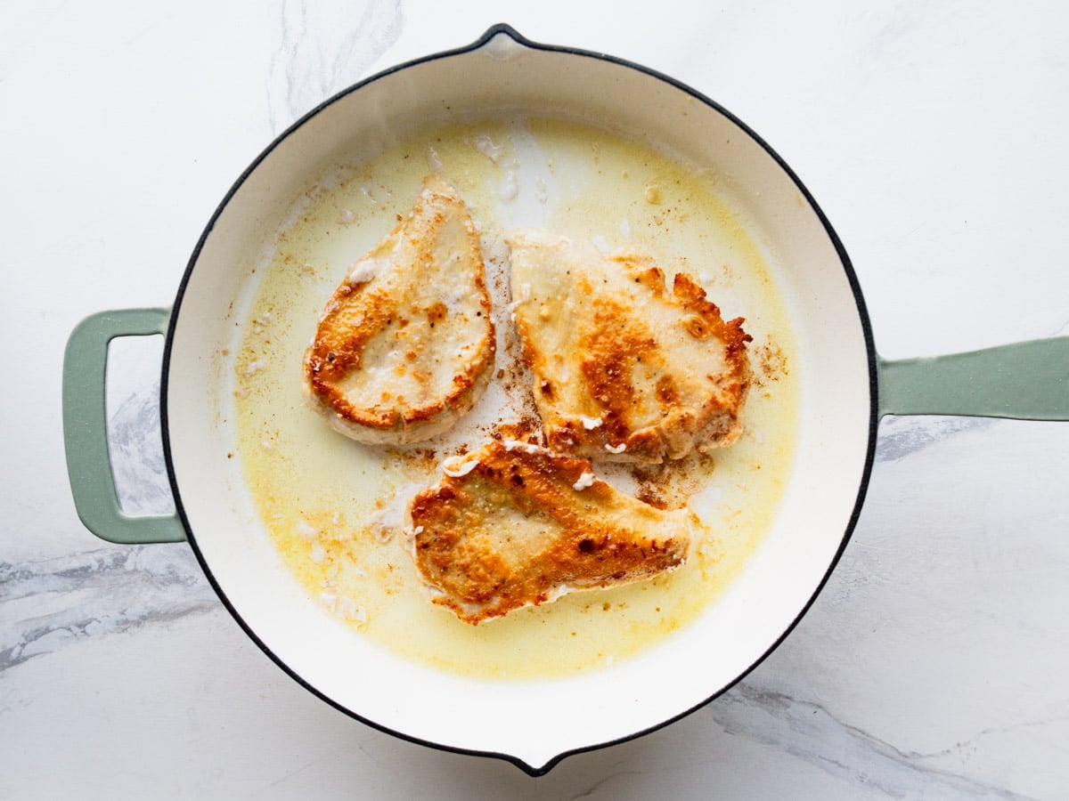 Browning chicken cutlets in the skillet.