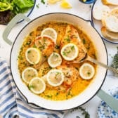 Horizontal overhead shot of skillet lemon chicken on a white table.