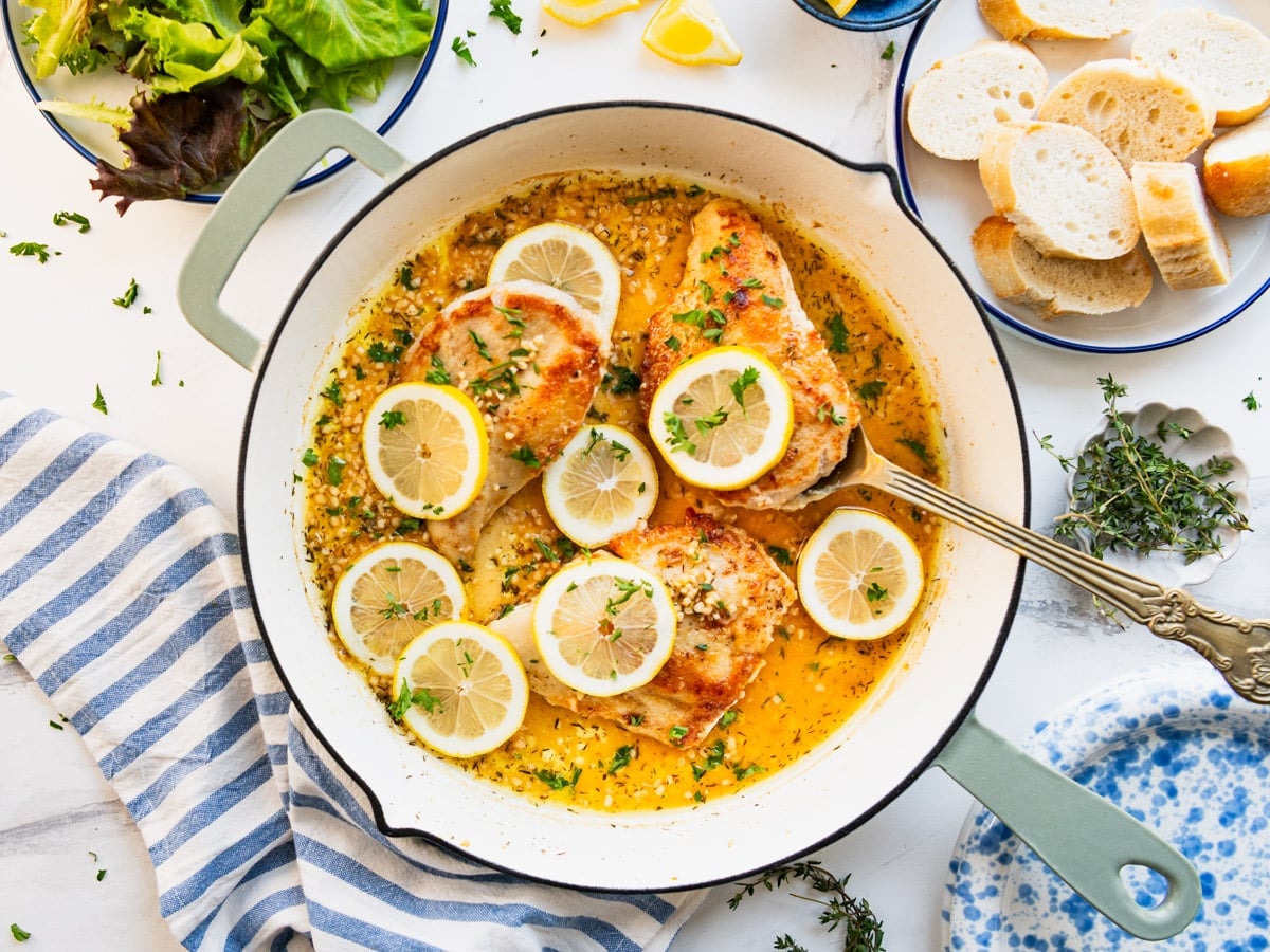 Horizontal overhead shot of skillet lemon chicken on a white table.