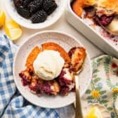 Horizontal overhead shot of a bowl of blackberry cobbler with vanilla ice cream on top.