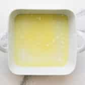 Melted butter in a white baking dish.
