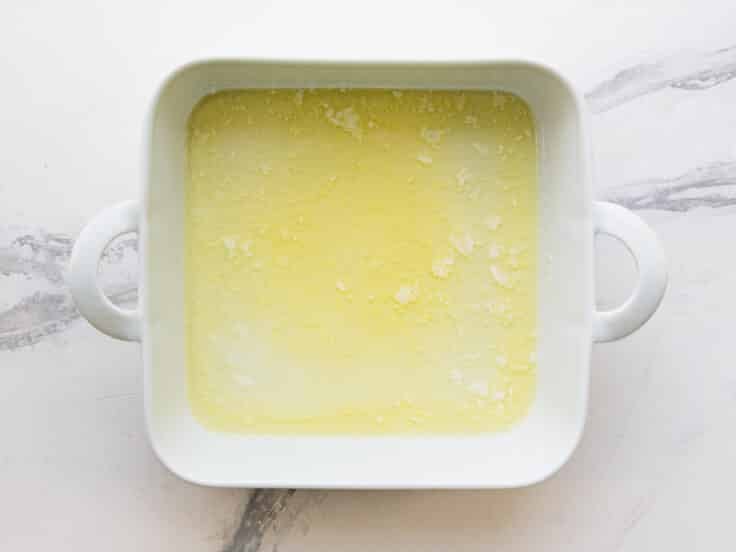 Melted butter in a white baking dish.