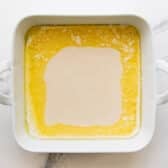 Pouring the batter over the melted butter.
