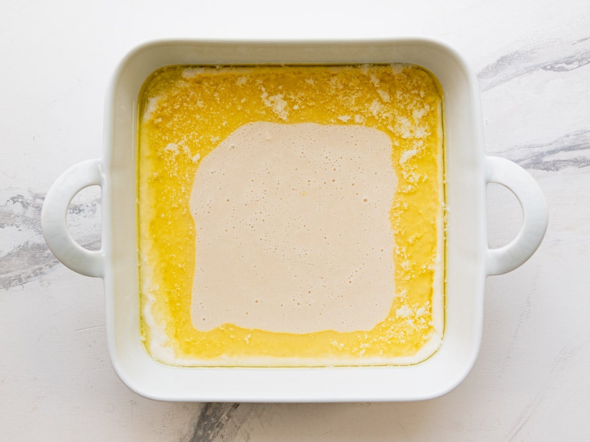 Pouring the batter over the melted butter.