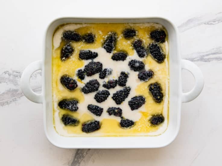 Sprinkling sugar on top of the cobbler before baking.