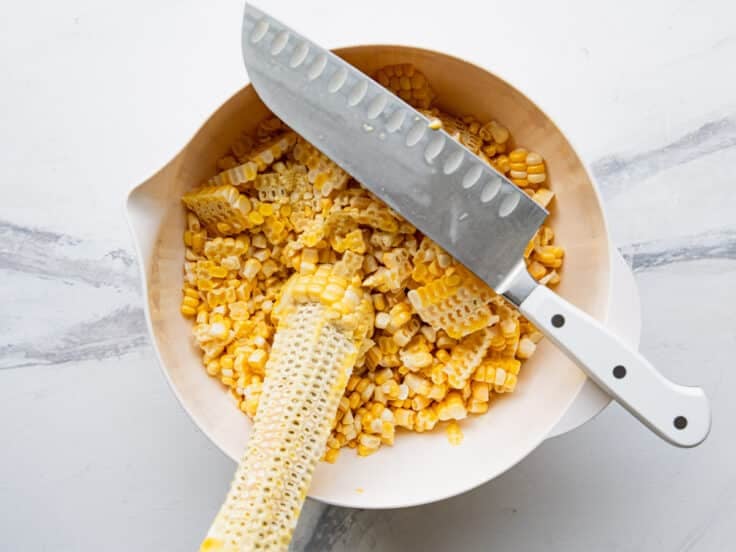 Cutting the kernels off of corn cobs.