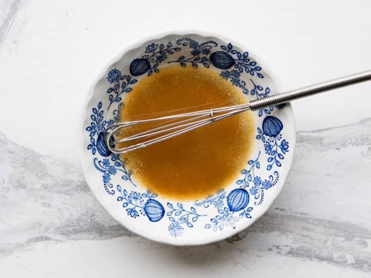 Whisking together the melted butter and sugar mixture.