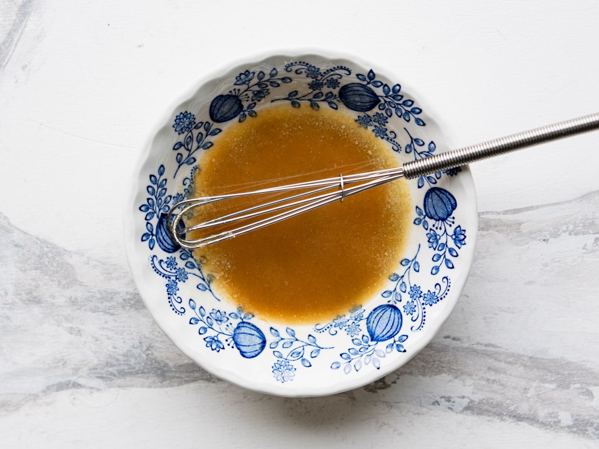 Whisking together the melted butter and sugar mixture.