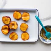 Brushing peaches with the melted butter mixture.