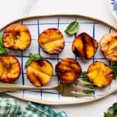 Horizontal overhead shot of a platter of grilled peaches.