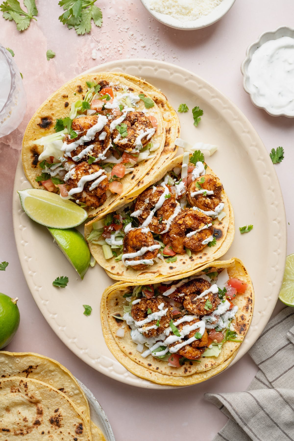 Overhead shot of easy shrimp tacos on a white oval platter.