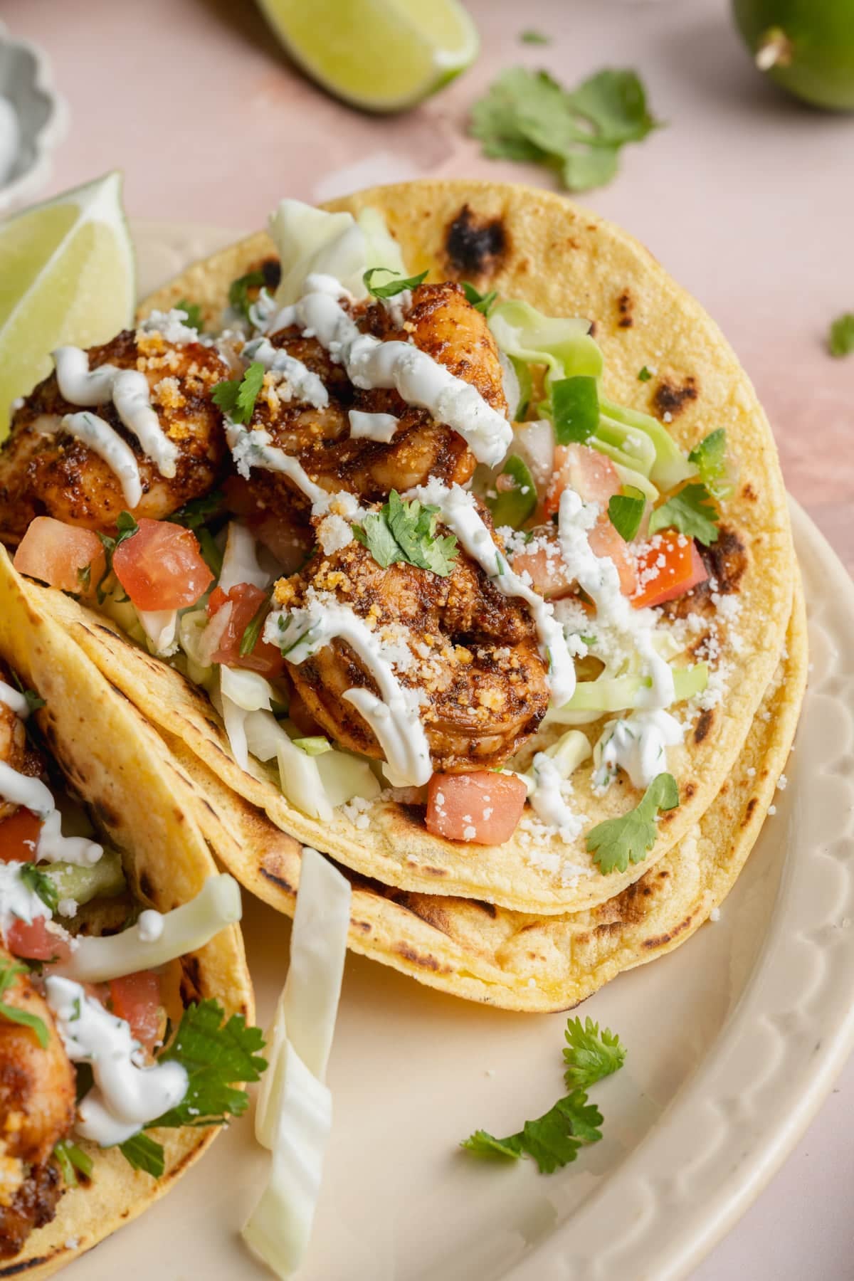 Side shot of easy shrimp tacos with lime crema.
