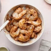 Seasoned raw shrimp in a bowl.