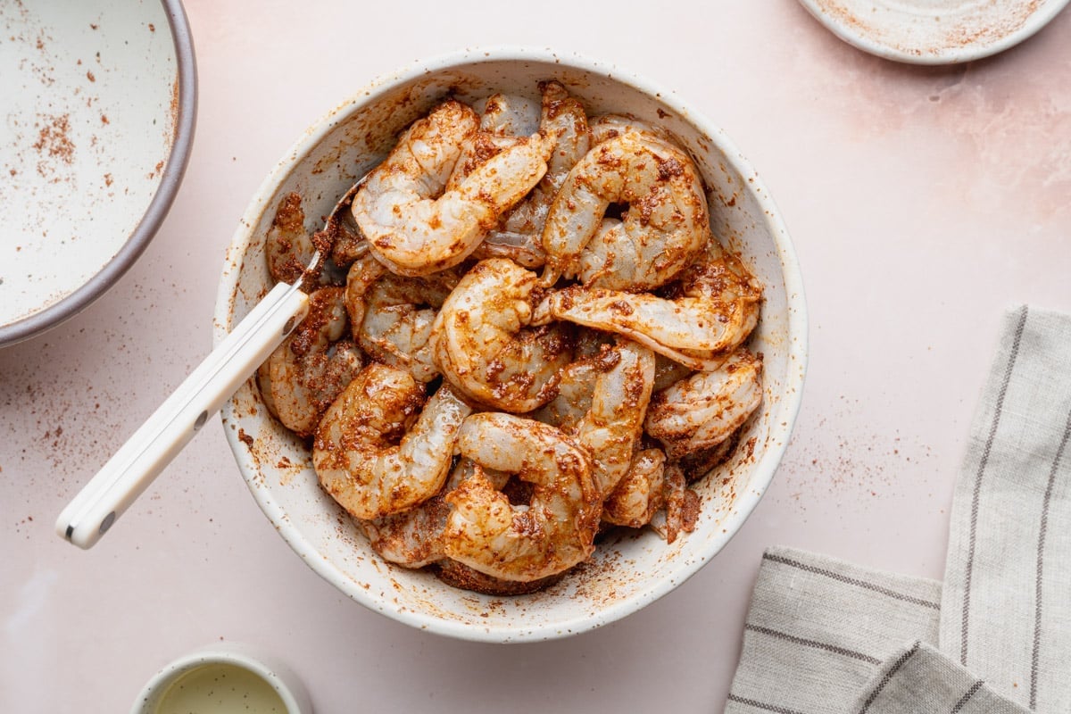 Seasoned raw shrimp in a bowl.