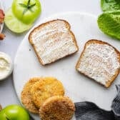 Spreading mayo on two slices of toasted bread.