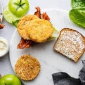 Assembling the fried green tomato BLT sandwich before adding the final piece of bread on top.