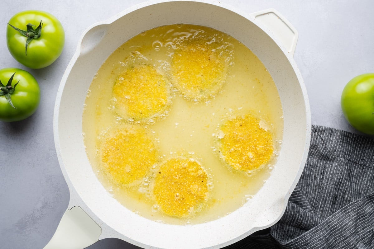 Frying green tomatoes in a skillet.