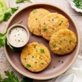 Horizontal overhead shot of fried green tomatoes on a plate with a side of creamy remoulade sauce.