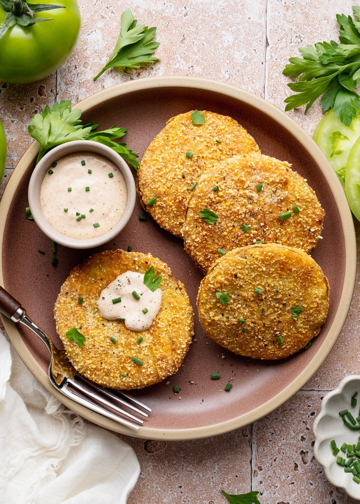 Overhead shot of fried green tomatoes on a plate with a side of creamy remoulade sauce.