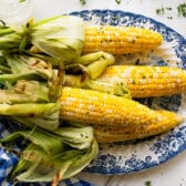 Horizontal overhead shot of a platter of grilled corn on the cob.