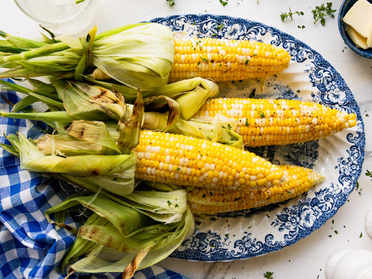 Horizontal overhead shot of a platter of grilled corn on the cob.