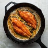 Cooking blackened catfish fillets in a cast iron pan.