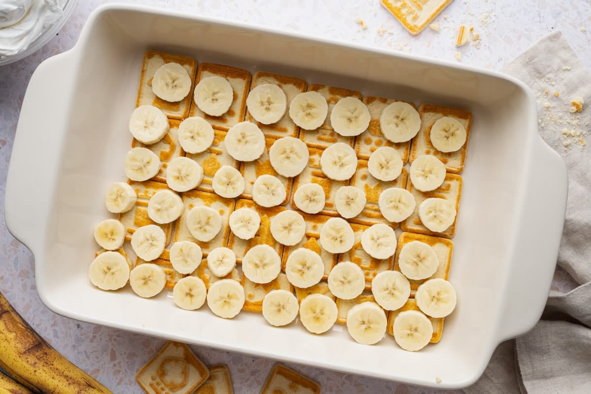 A layer of sliced bananas on top of the cookies.