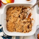 Horizontal overhead image of a white baking dish full of apple crumble.