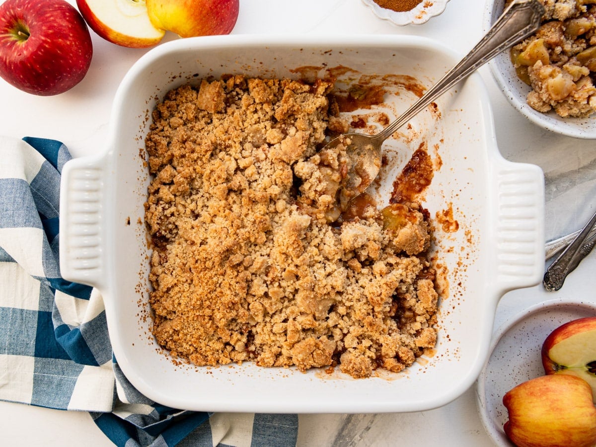 Horizontal overhead image of a white baking dish full of apple crumble.
